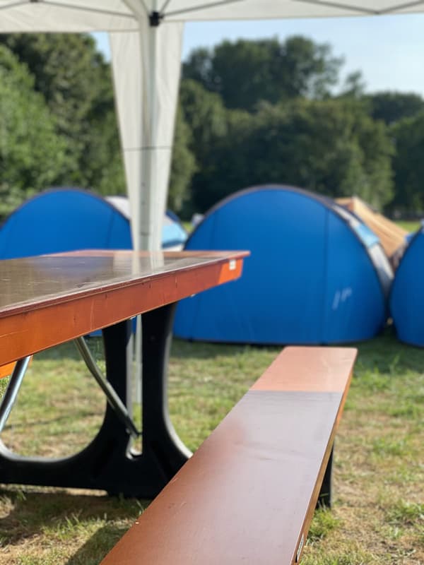 Picknickbord och tält på campen